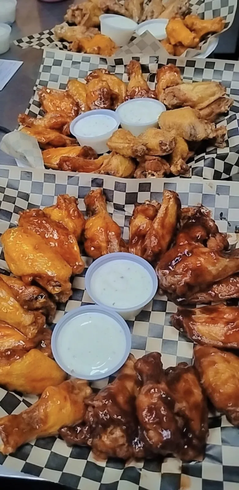 Baskets of sauced wings lined up in the IST NOLA kitchen
